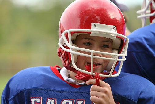 A young football player using a mouthguard