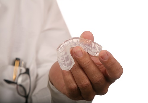 A doctor holding a mouthguard 