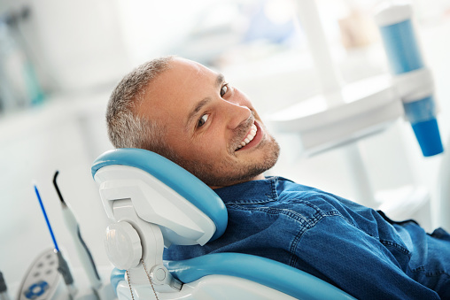 A man smiling after getting a painless tooth extraction